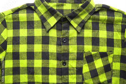 Plaid shirt checked cotton flannel of bright yellow and black colors with a button-down collar and front pocket. Lumberjack square pattern on casual clothes for men and women, close up top view 