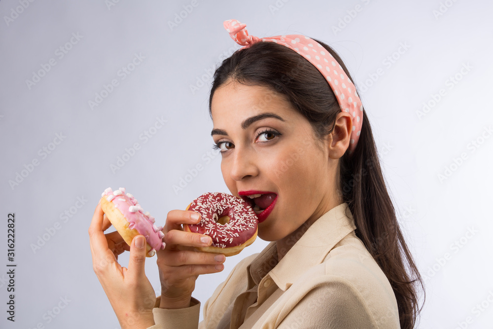 bellissima ragazza gioca con dei donuts su sfondo bianco