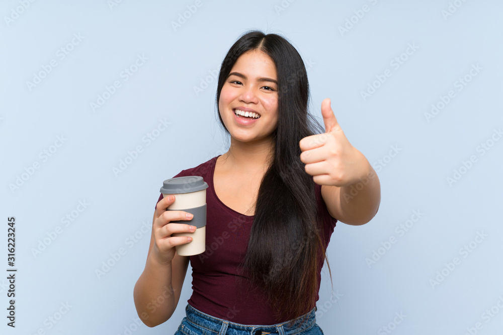 Young teenager Asian girl holding a take away coffee with thumbs up because something good has happened Young teenager Asian girl holding a take away coffee with thumbs up because something good has happened