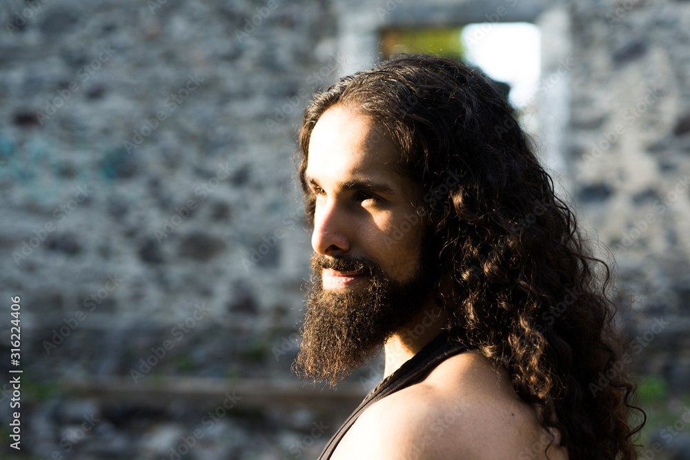 Handsome bearded man with long dark hair. Man style and fashion concept.  Close up portrait of