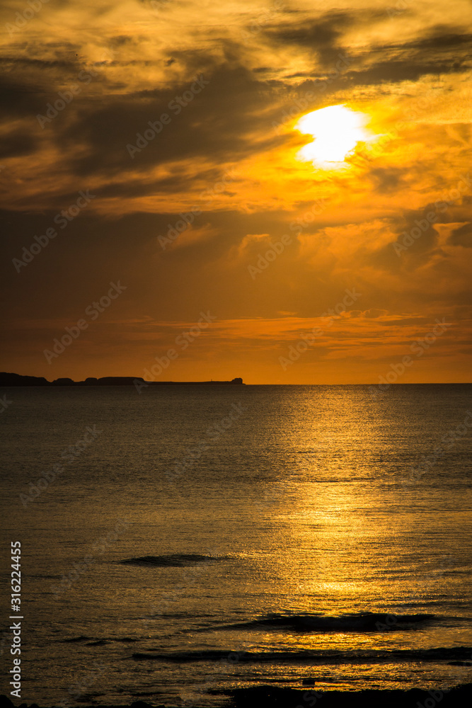 Puesta de sol sobre Islas Marietas en México con un cielo dorado medio nublado