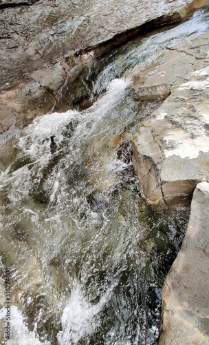 Sunny cascading stream in the rocky basin of the Lewis River in the Gifford Pinchot National Forest on a bright summer day in Skamania County southern Washington State  photo