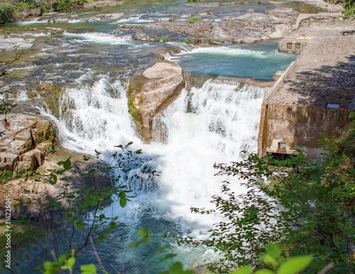 Majestic Steamboat Falls and the Fish Ladders of the North Umpqua National Forest gushing from a blue drainage in the mountains of Douglas County southern Oregon in the springtime  photo