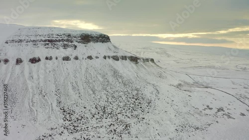 Drone footage of a snow blanketed Penyghent, Yorkshire Dales National Park, photo