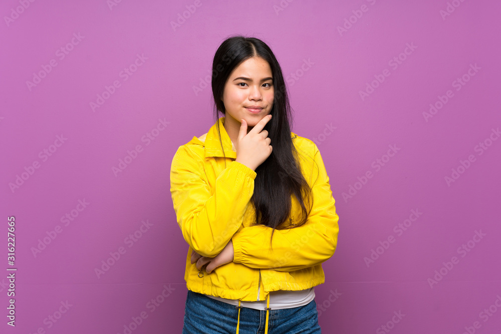 Young teenager Asian girl over isolated purple background thinking Young teenager Asian girl over isolated purple background thinking