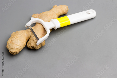 Fresh ginger  whole root  on gray background. Herbal therapy concept.