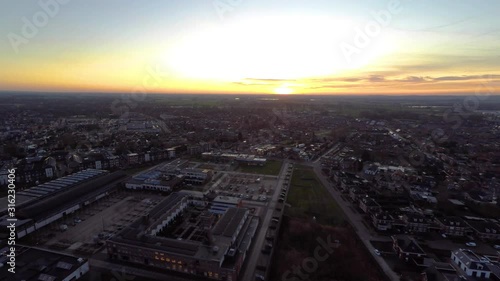 Jib down of small Dutch town with the sun setting at the horizon. Shot in Ulft, the Netherlands photo