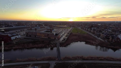 Jib up of small Dutch town wit the sun setting at the horizon. Shot in Ulft, the Netherlands photo