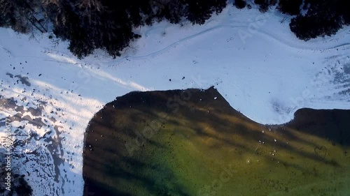 Aerial flyby over winter landscape of Gruner See, famous green lake in Tragoss, Styria, Austria. Travel destination. Look at mountains and forests surrounding the frozen lake. photo