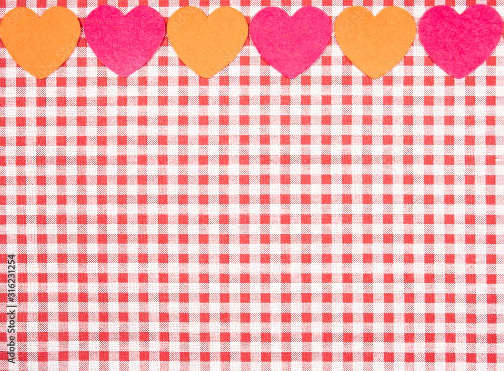 background with red and white Vichy fabric for Valentine's Day with pink and orange hearts. valentines day concept background with red and white Vichy fabric for Valentine's Day with pink and orange hearts. valentines day concept