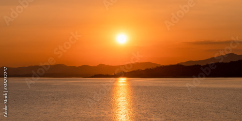 Beautiful sunset over the mountains by the lake. © Guitafotostudio