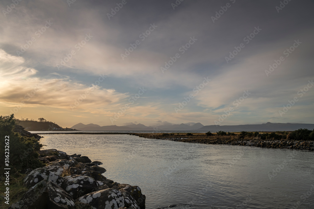 A bracketed HDR warm winter image from the Alpplecross river to a distant Isle of Skye from the Applecross Peninsula, Scotland. 31 December 2019