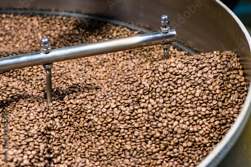 Fresh roasted coffee arabica beans have been cooled down in the roaster cooling bin/tray after completed roasting process.