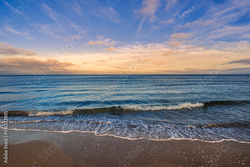 Strand, Welle, Meer, Himmel diagonal im Vordergrund, mit Wolkenstimmung © dreamcatcher