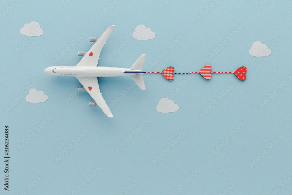 Fototapeta White top view Airplane . Valentines day hearts blue cloud sky background with copy space for your text. Flat lay.