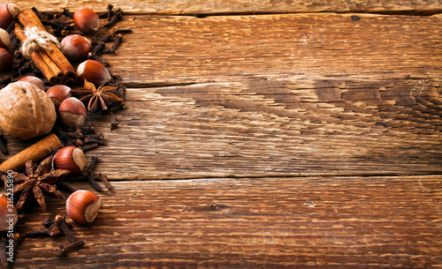 Spices on a old wooden background. Cinnamon, nuts, anise frame. Autumn background. Christmas background. Top view.