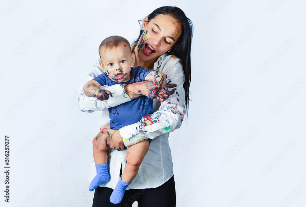 Happy mother holding a baby in her arms. Painted in skin hands. Family playing. Mothers day concept. Mother playing with her baby. Lifestyle childhood concept. Happy mother holding a baby in her arms. Painted in skin hands. Family playing. Mothers day concept. Mother playing with her baby. Lifestyle childhood concept.