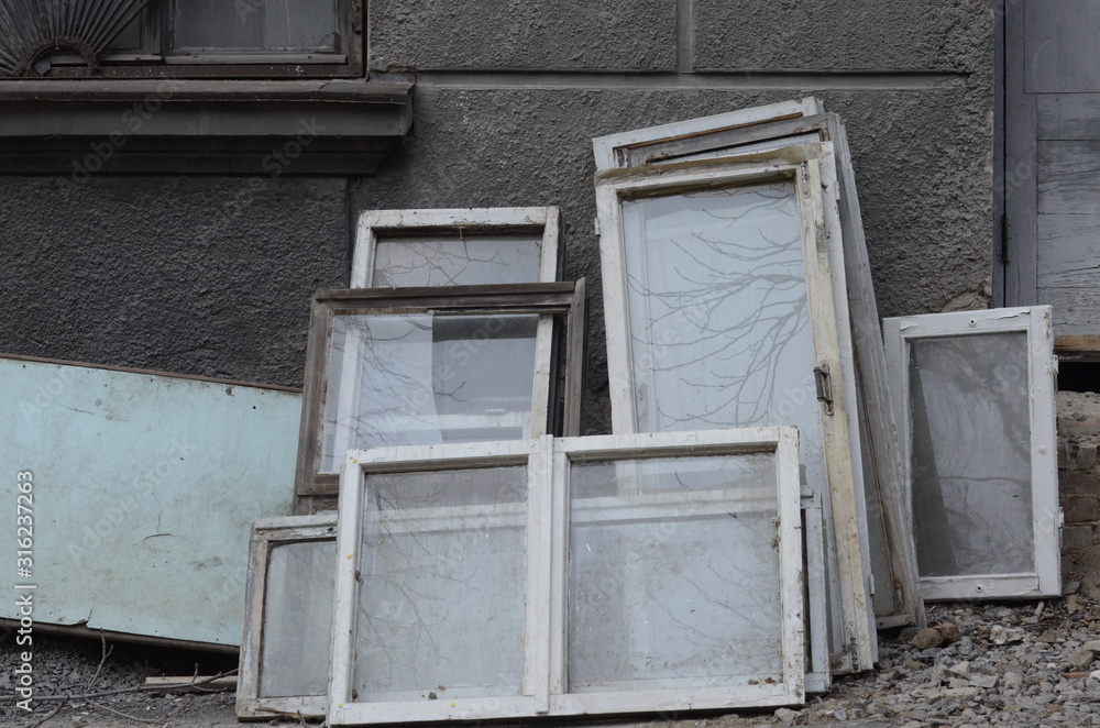 Heap of construction debris from old wooden window frames with glass. Construction waste from renovation house. Recycling of end-of-life building glass. Broken materials after upgrading windows Heap of construction debris from old wooden window frames with glass. Construction waste from renovation house. Recycling of end-of-life building glass. Broken materials after upgrading windows