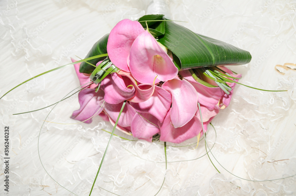 Ramo de flores de alcatraz de color rosa sobre el vestido de una novia foto  de Stock | Adobe Stock