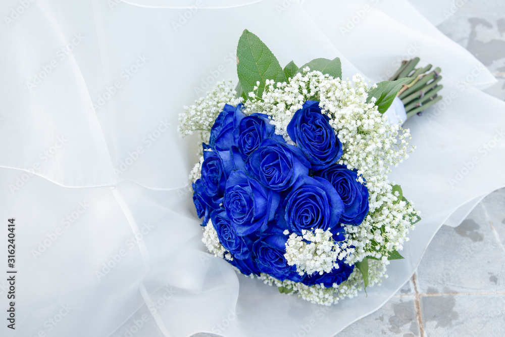 Elegante ramo de rosas de color azul y flores blancas sobre el vestido de  una novia фотография Stock | Adobe Stock