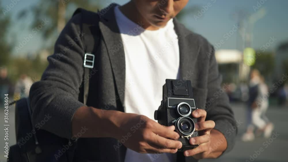 Right to left pan real time portrait shot of a young Asian man taking a picture on an old camera. Tourist in Moscow. Moscow is the capital of Russia. Right to left pan real time portrait shot of a young Asian man taking a picture on an old camera. Tourist in Moscow. Moscow is the capital of Russia.