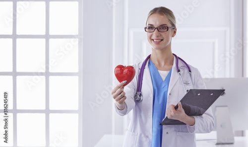 Doctor with stethoscope holding heart, isolated on white background photo