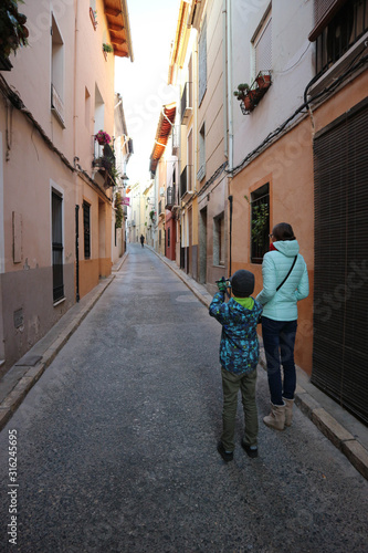 Young photographer with his mother on narrow street in old spanish town