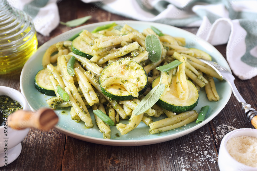 Italian penne pasta with roasted zucchini, pesto sauce and green beans