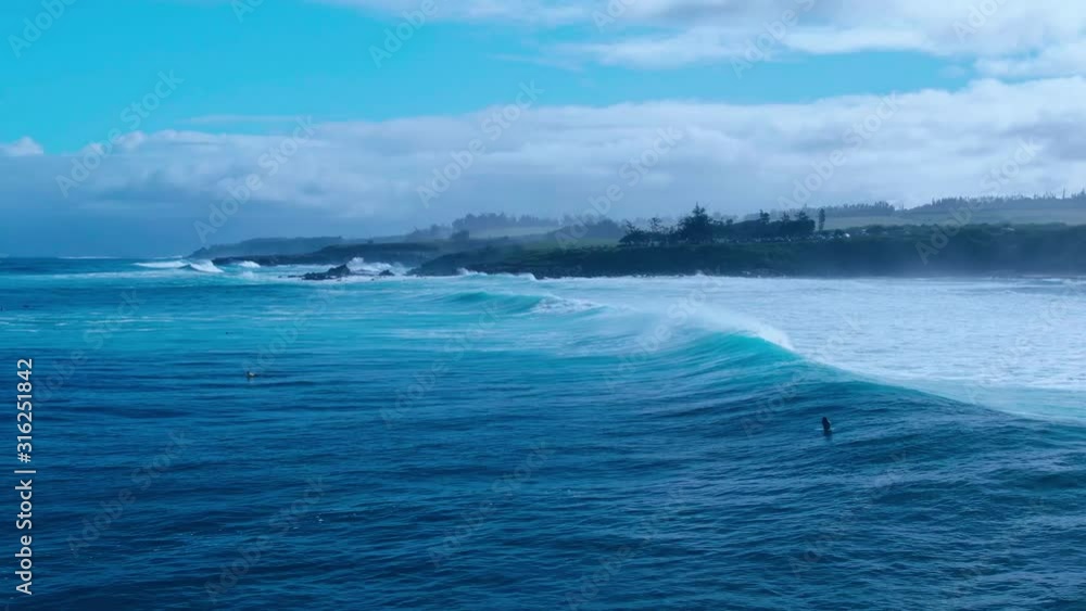 White big waves of ocean crushing on shore of tropical island in Hawaii on beautiful dramatic scenery with cloudy sky background White big waves of ocean crushing on shore of tropical island in Hawaii on beautiful dramatic scenery with cloudy sky background