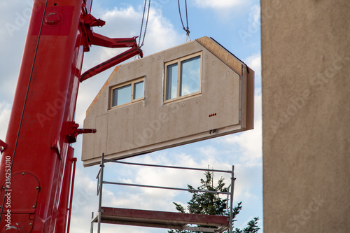 Wallpaper Mural Truck crane has component from prefabricated house to construction site with visible scaffolding Torontodigital.ca