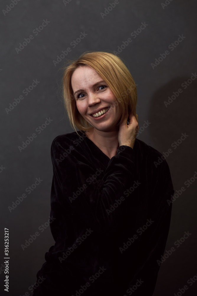 Woman is smiling on a dark background. Woman is smiling on a dark background.