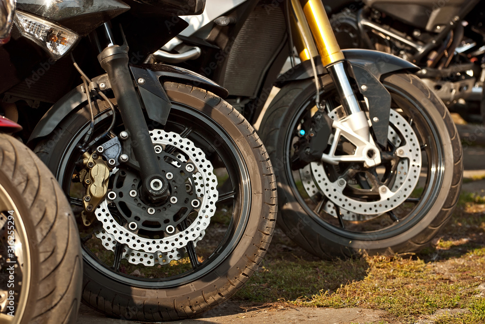 Fototapeta premium Motorcycle wheel closeup. Motorcycle metal parts. Biker meeting in the city.