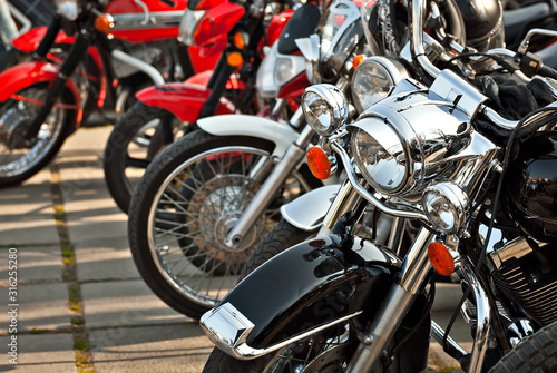 Motorcycles are placed in a row. Headlight closeup. Motorcycle chrome elements.