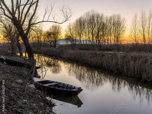 Typical wooden boat of the wetland known as Padule di Fucecchio, Porto dell'Uggia, Tuscany, Italy, at sunset photo