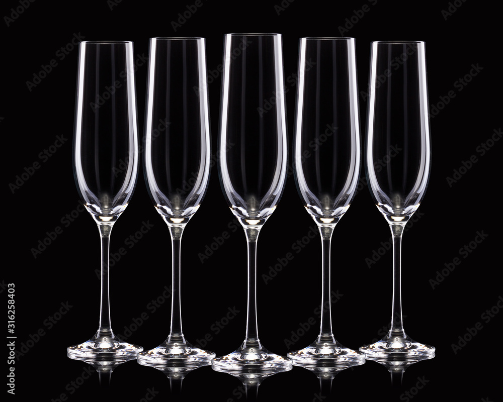 Set of empty luxury champagne glasses in a row isolated on a black background Set of empty luxury champagne glasses in a row isolated on a black background