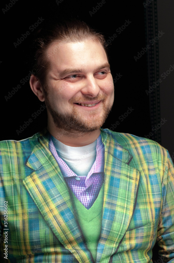 low-key portrait of handsome bearded funny man in green hipster coat laughing and looking away isolated on black low-key portrait of handsome bearded funny man in green hipster coat laughing and looking away isolated on black