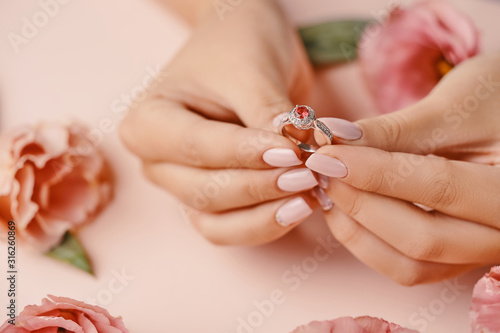 Close up of woman's hand holding elegant diamond ring.