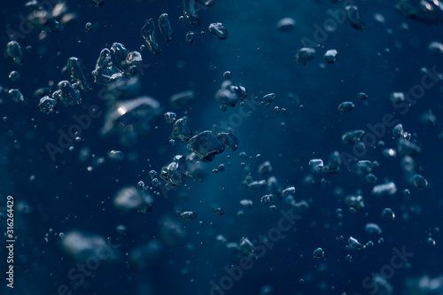 Abstract underwater scene sun ray and air bubbles in deep blue sea