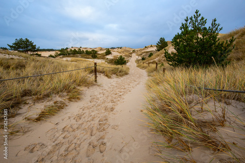 Obraz na płótnie Dunes in the Slowinski National Park. Landscape with beautiful sky, clouds and dunes in the sun. Czolpino, Leba, Poland. w salonie