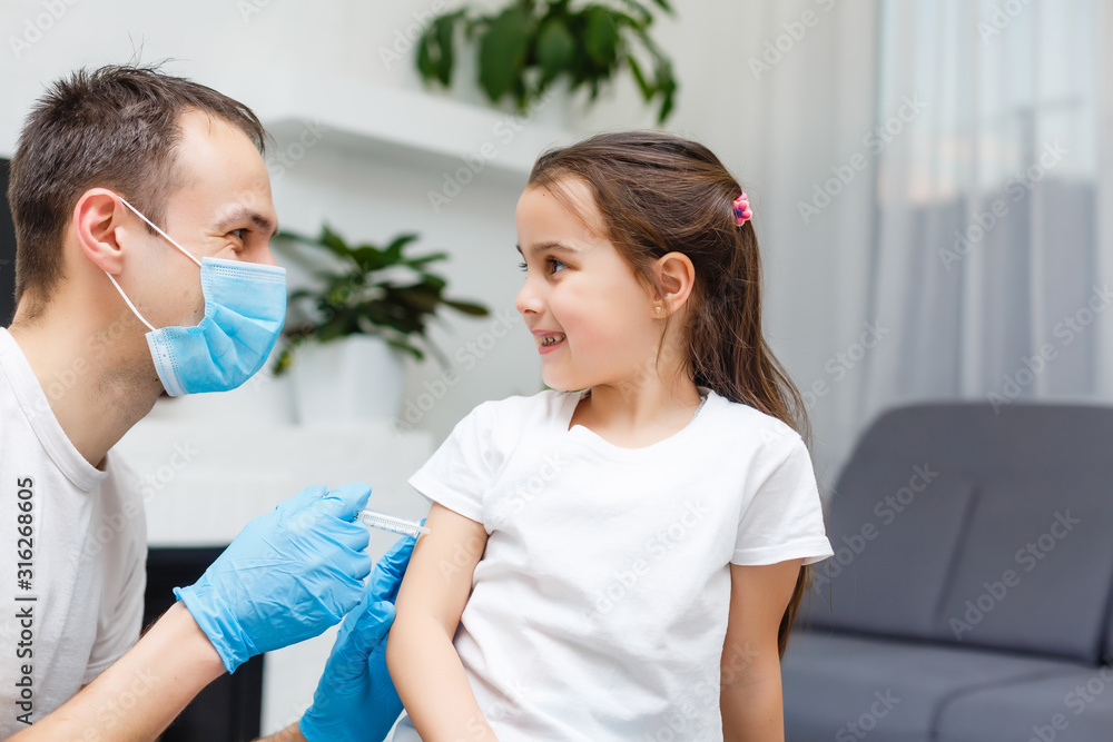 Playful little daughter playing funny game as doctor having fun with dad sitting on couch, cute child girl pretending nurse in medical uniform holding stethoscope listening to father patient at home Playful little daughter playing funny game as doctor having fun with dad sitting on couch, cute child girl pretending nurse in medical uniform holding stethoscope listening to father patient at home