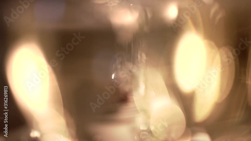 Transparent glasses with cold champagne on a table in soft evening lighting, close-up. Golden-colored sparkling wine with bubbles at a fancy restaurant. Noble drink and appetizer at romantic dinner.