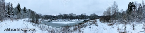 Panoramic view with winter river and snow forest. Beautiful winter landscape