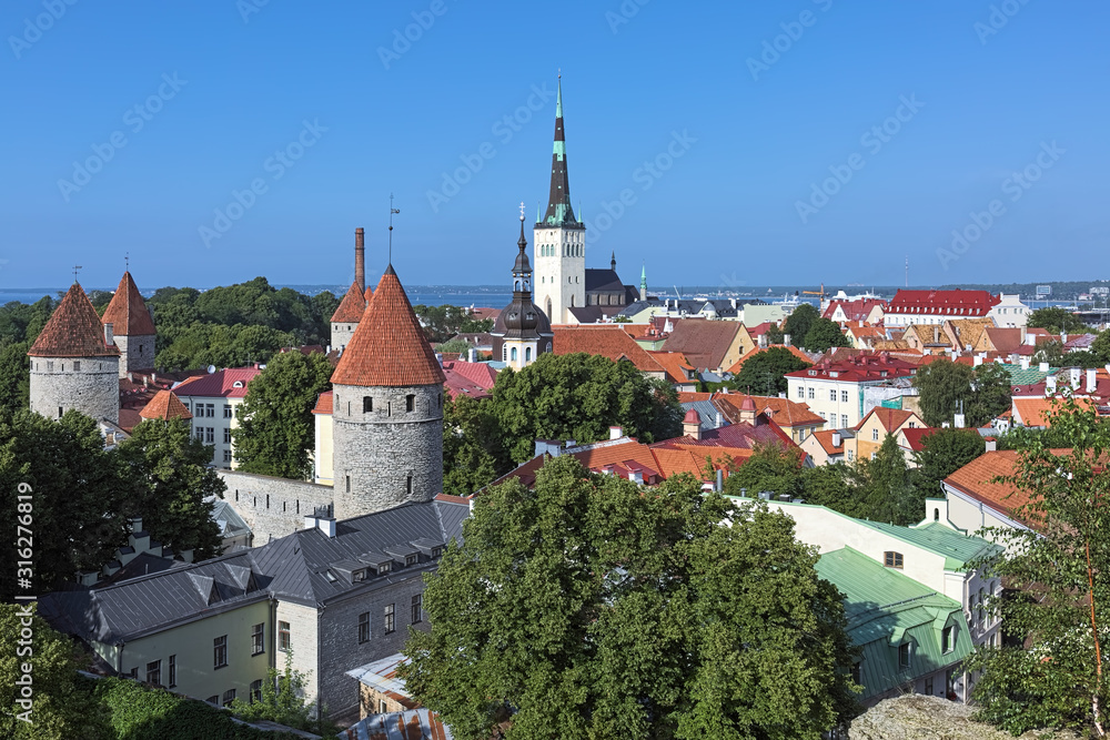 Tallinn, Estonia. Lower Town with St. Olaf's Church, Transfiguration Cathedral, towers of Tallinn City Wall, and Tallinn Bay of Baltic Sea in the background. View from the Patkuli viewing platform.