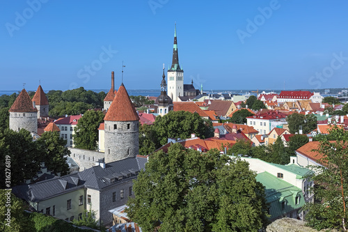 Tallinn, Estonia. Lower Town with St. Olaf's Church, Transfiguration Cathedral, towers of Tallinn City Wall, and Tallinn Bay of Baltic Sea in the background. View from the Patkuli viewing platform. photo