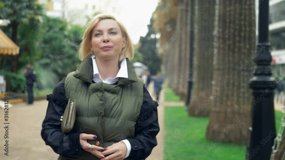 beautiful stylish trendy blond woman walking in a city Park in autumn beautiful stylish trendy blond woman walking in a city Park in autumn