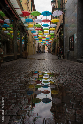 ombrelli appesi con riflesso in pozzanghera © glllnz