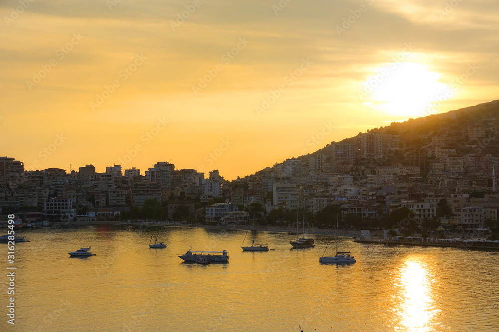 AERIAL: Golden evening sun rays illuminate the picturesque Albanian Riviera.