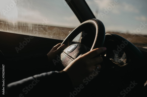 Female hands of the driver on the steering wheel while riding. © velimir