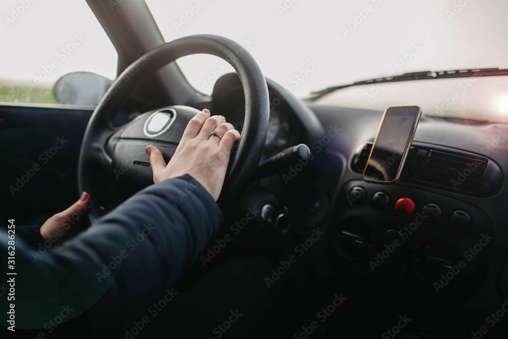 female hand holds the steering wheel of a car. Woman driver concept. female hand holds the steering wheel of a car. Woman driver concept.
