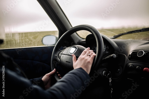 Female hands of the driver on the steering wheel while riding.